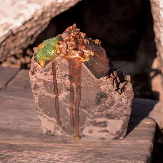 a handcrafted cold process soap with a unique Hoggel-inspired design. The textured bar hints at nourishing ingredients like tussah silk, hempseed oil, and avocado oil, while walnut shell powder offers gentle exfoliation. Rich scent notes of tobacco, vanilla, and spices evoke a luxurious, moisturizing skincare experience.